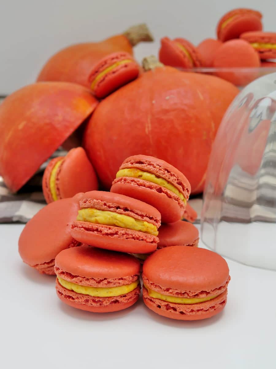 brightly coloured orange macarons next to Japanese chestnut pumpkin the same colour