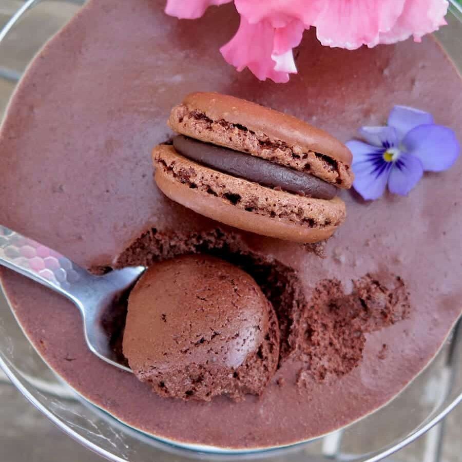 spoonful of dark chocolate mousse next to a macaron