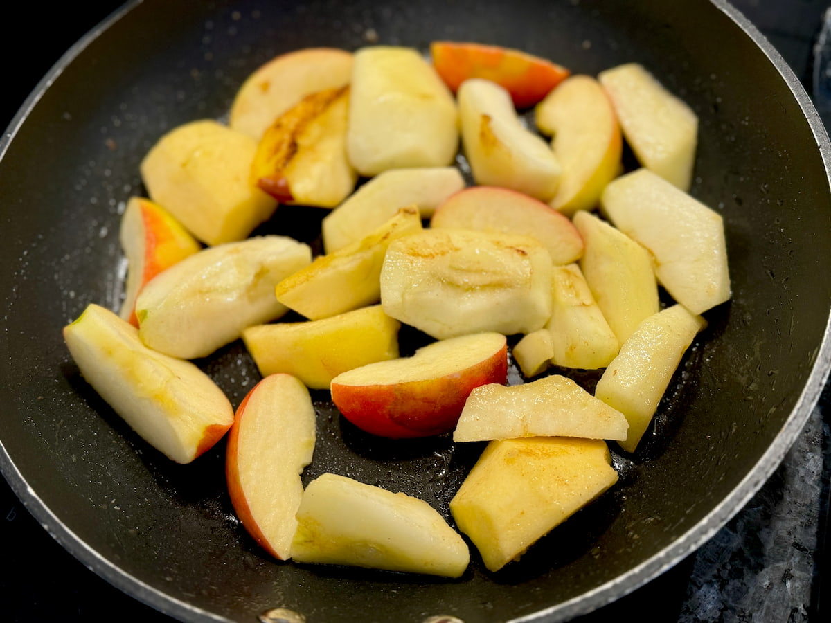 cooking apple slices in butter in a frying pan