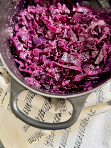 cooking pot with vibrant red cabbage cooked in vinegar, apple, onion and spices